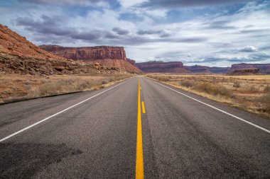 Canyonlands Ulusal Parkı, Needles İlçesi, Monticello, Utah yakınlarındaki Indian Creek Koridoru Manzarası boyunca güneşli bir günde görülen kırmızı kumtaşı popoları ve tasarruflarının ikonik görüntüsü