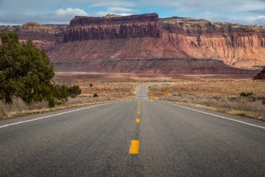 Canyonlands Ulusal Parkı, Needles İlçesi, Monticello, Utah yakınlarındaki Indian Creek Koridoru Manzarası boyunca güneşli bir günde görülen kırmızı kumtaşı popoları ve tasarruflarının ikonik görüntüsü