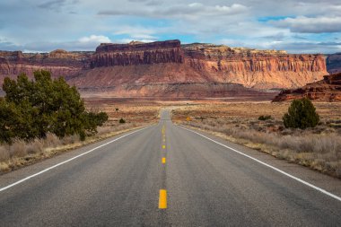 Canyonlands Ulusal Parkı, Needles İlçesi, Monticello, Utah yakınlarındaki Indian Creek Koridoru Manzarası boyunca güneşli bir günde görülen kırmızı kumtaşı popoları ve tasarruflarının ikonik görüntüsü