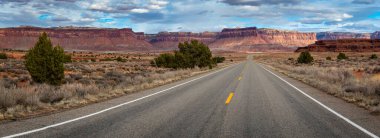Canyonlands Ulusal Parkı, Needles İlçesi, Monticello, Utah yakınlarındaki Indian Creek Koridoru Manzarası boyunca güneşli bir günde görülen kırmızı kumtaşı popoları ve tasarruflarının ikonik görüntüsü