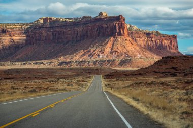 Canyonlands Ulusal Parkı, Needles İlçesi, Monticello, Utah yakınlarındaki Indian Creek Koridoru Manzarası boyunca güneşli bir günde görülen kırmızı kumtaşı popoları ve tasarruflarının ikonik görüntüsü