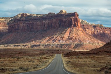 Canyonlands Ulusal Parkı, Needles İlçesi, Monticello, Utah yakınlarındaki Indian Creek Koridoru Manzarası boyunca güneşli bir günde görülen kırmızı kumtaşı popoları ve tasarruflarının ikonik görüntüsü
