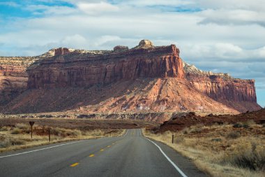 Canyonlands Ulusal Parkı, Needles İlçesi, Monticello, Utah yakınlarındaki Indian Creek Koridoru Manzarası boyunca güneşli bir günde görülen kırmızı kumtaşı popoları ve tasarruflarının ikonik görüntüsü