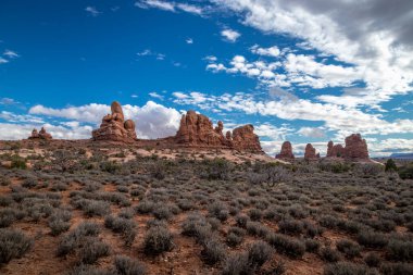 Güneşli bir günde, Taret Kemeri 'nin ve etrafındaki kumtaşı kaya oluşumlarının üzerindeki güzel bulutlar Arches Ulusal Parkı, Moab, Utah