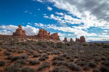 Güneşli bir günde, Taret Kemeri 'nin ve etrafındaki kumtaşı kaya oluşumlarının üzerindeki güzel bulutlar Arches Ulusal Parkı, Moab, Utah