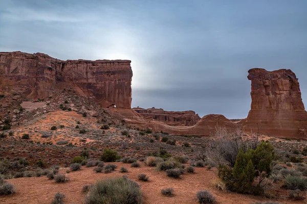 Massive sandstone rock towers in the Park Avenue Section of Arches National Park with dramatic storm clouds looming overhead, Moab, Utah