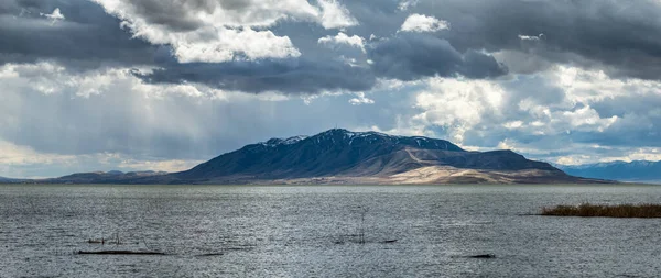 Karla kaplı göl dağlarının güzel manzarası gökyüzünde dramatik bulutlar, Utah Gölü Eyalet Parkı, Provo Utah