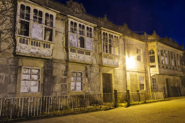 Facade of abandoned and ruined modernist houses of the old canning makers in Arousa Island at night