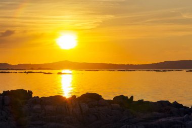 Arousa Haliç ile kıyı kayaların ön plan üzerinde altın batımında
