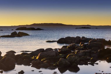 Salvora Island alacakaranlıkta Atlantik milli park ile kıyı roks ön planda
