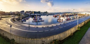 Şafakta Vilanova de Arousa balıkçı limanında demirli teknelerin panoramik manzarası