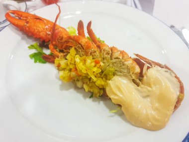 Porselen tabakta servis edilen mayonez soslu yarım ıstakoz.