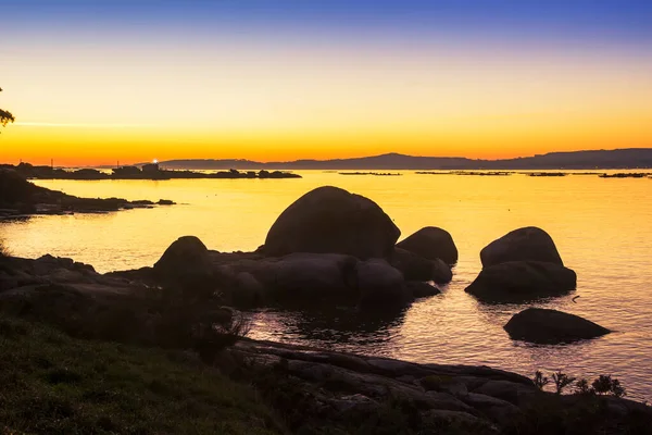 アロサ島の岩の多い海岸の黄金の夕暮れ時に灯台が点滅 — ストック写真
