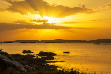 Arousa Adası 'ndan altın gün batımında Arousa Körfezi üzerinde güneş ışınları