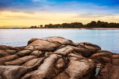 Arousa Adası 'ndaki Sahil Kayalıkları ve Salinas Koyu' nda Carreiron doğal parkı arka planda.