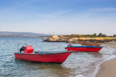 Galiçya, İspanya 'daki Arousa Adası' ndaki Riason plajına demirlemiş kırmızı balıkçı tekneleri.