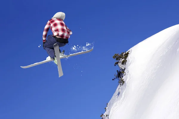 Flygande skidåkare på hoppa inhigh på snötäckta berg — Stockfoto