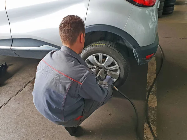 Worker changes the car's tire — Stock Photo, Image