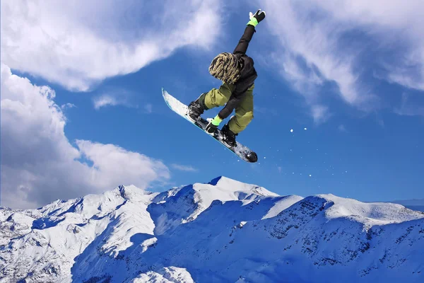 Snowboarder pulando pelo ar com céu azul no fundo — Fotografia de Stock