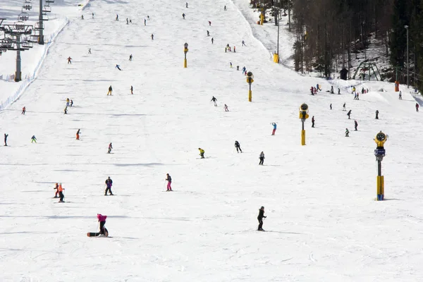 Множество лыжников и сноубордистов на склоне горнолыжного курорта — стоковое фото