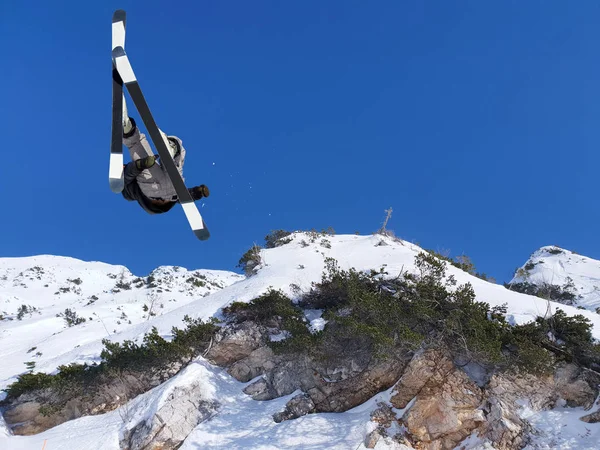 极端滑雪者从山蓝的天空跳下后格 — 图库照片