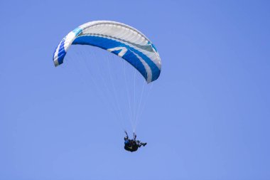 Arka plan ekstrem spor olarak mavi gökyüzünde yamaç paraşütü