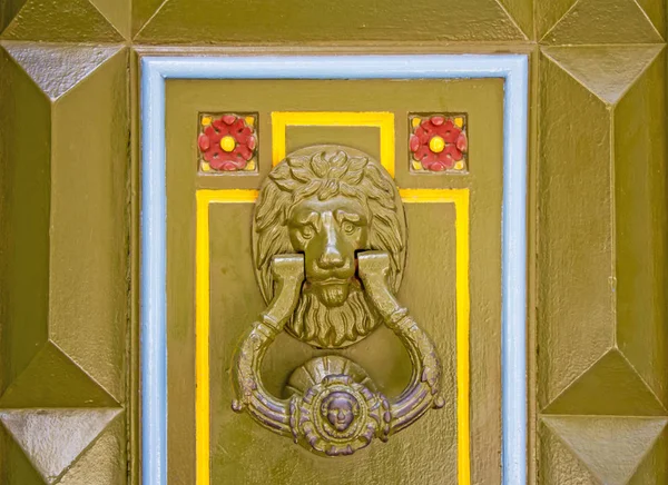 Old metal doorknob in the shape of lion head on old wooden door — Stock Photo, Image