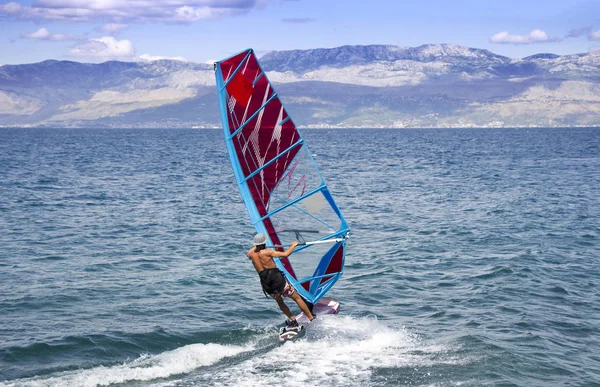 Jovem windsurfista nas ondas do mar — Fotografia de Stock