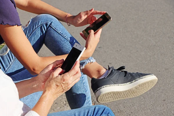 Two young girls watching smart mobile phones — Stock Photo, Image