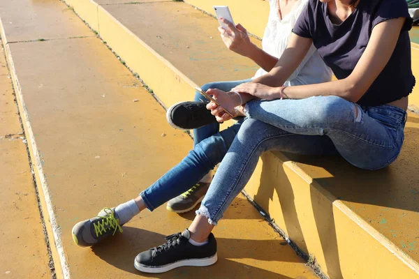 Two young girls watching smart mobile phones — Stock Photo, Image