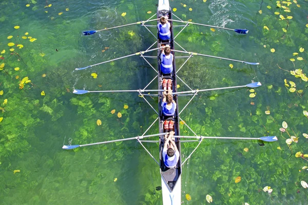 Yeşil su üzerinde erkekler dörtlü kürek takımı — Stok fotoğraf