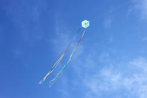 Pipa colorida voando e céu azul como fundo — Fotografia de Stock