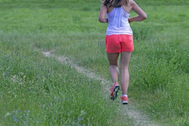 Kırsal bir yolda koşan genç bir kadın. 