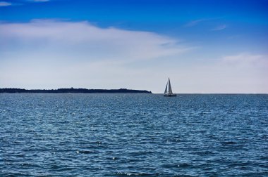 Mavi dalgaları ve yatı olan deniz manzarası, Slovenya 'daki Akdeniz' de küçük bir tekne.