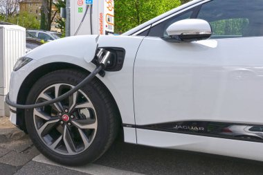 AACHEN, NRW, GERMANY - 23 Nisan 2019: Elektrikli araba, Jaguar, elektrik kablosu ile kamu elektrik yükleme koluna bağlandı