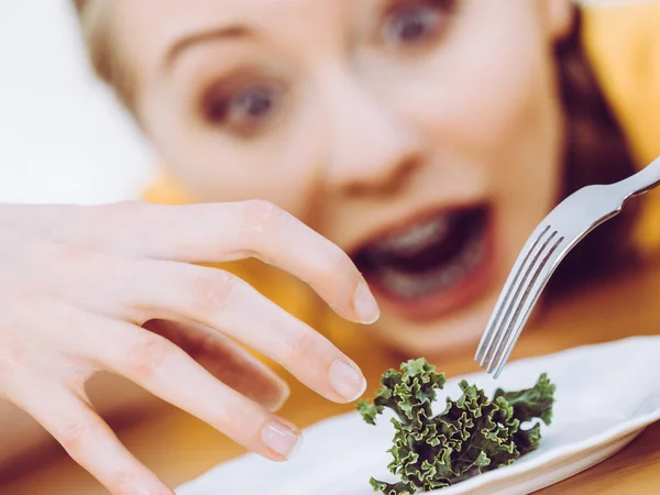 ショックを受けた若いのブロンドの女性は神経性無食欲症や Builimia プレートの小さな緑の野菜を持っていることを扱います ダイエット 摂食障害の問題 — ストック写真