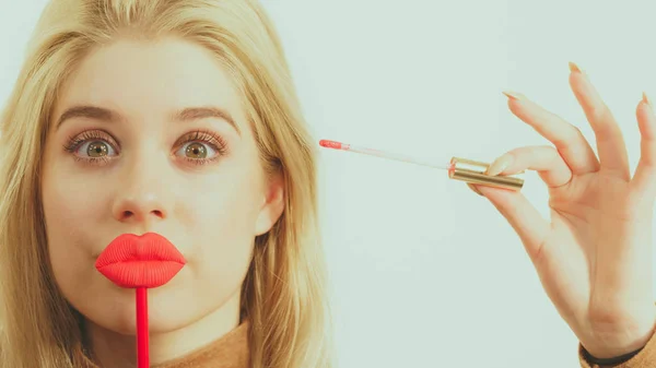 여자가 립스틱이나 립글로스를 바르고 입술을 막대기에 붙이는 마무리 짓는다 — 스톡 사진