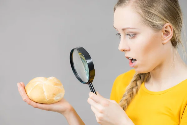 Chockad Kvinna Håller Bröd Rulle Och Förstoringsglas Undersöka Vete Produkt — Stockfoto