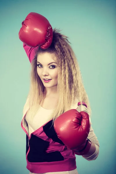 面白いですブロンド女の子女性ボクサーで大楽しいです赤手袋遊びスポーツボクシングスタジオショットオン青 — ストック写真