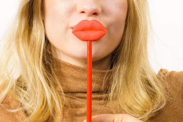 年轻的女人紧紧抓住大大的红色假嘴唇Lip Injection Beauty Standards Concept — 图库照片