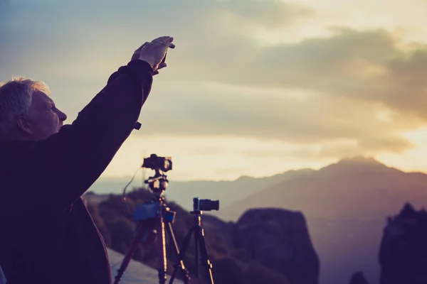 夕暮れ映画ビデオ フィン山を取って三脚にプロのカメラの男性観光客 — ストック写真