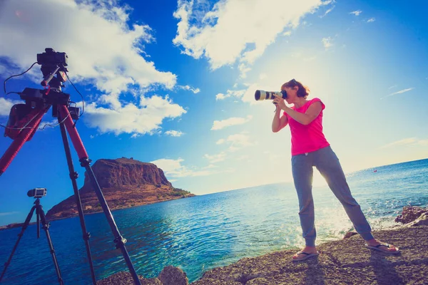 海岸で写真を撮るカメラを持つ女性 背景にはロッキー島のMonemvasia ギリシャ ペロポネソス ラコニア 目的地 — ストック写真