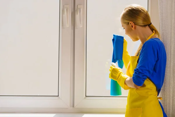 Młoda Kobieta Żółtych Rękawiczkach Czyści Szybę Domu Szmatą Rozpylanym Detergentem — Zdjęcie stockowe