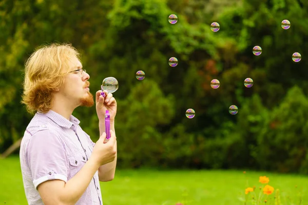 Feliz Jovem Adulto Homem Soprando Bolhas Sabão Natureza Verde Primavera — Fotografia de Stock