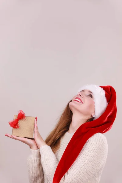 Смеющаяся Женщина Шляпе Санта Клауса Держит Золотую Подарочную Коробку Красным — стоковое фото