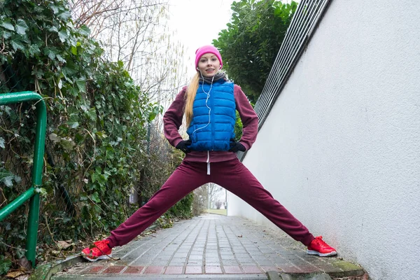 户外运动 运动服创意 穿着保暖运动服的女人在秋天进行锻炼 伸展腿 — 图库照片