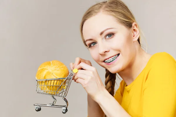 グルテン食品のコンセプトを購入する パンの小片とショッピングカートトロリーを保持女性 — ストック写真