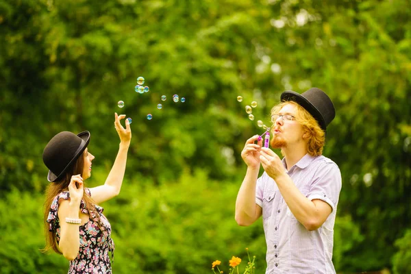 Happy Funny Hipster Couple Playing Together Blowing Soap Bubbles Outdoor — Stock Photo, Image
