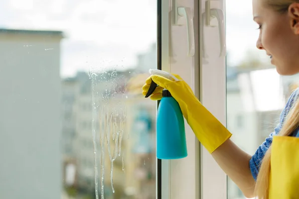 Ung Kvinna Gula Handskar Rengöringsfönster Med Blå Trasa Och Spray — Stockfoto