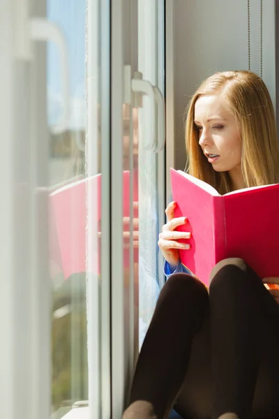 Junge Frau Sitzt Auf Fensterbank Und Liest Interessantes Buch Und — Stockfoto